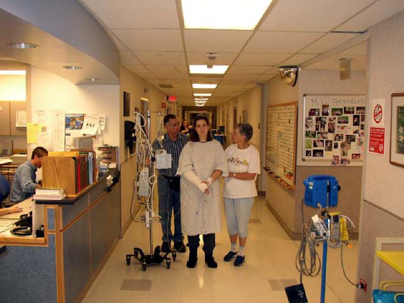 Marla takes a few tentative steps around outside her room. Due to dizziness and fatigue from her pain medication, she can't go far yet.