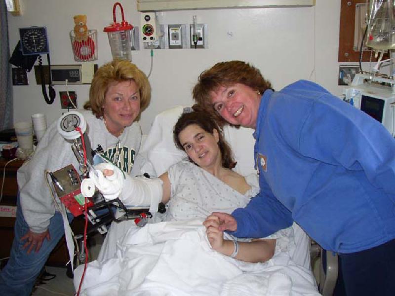 Julie Andersen and Liz Beerman give Marla a hug and check out the workings of her CPM range-of-motion machine.