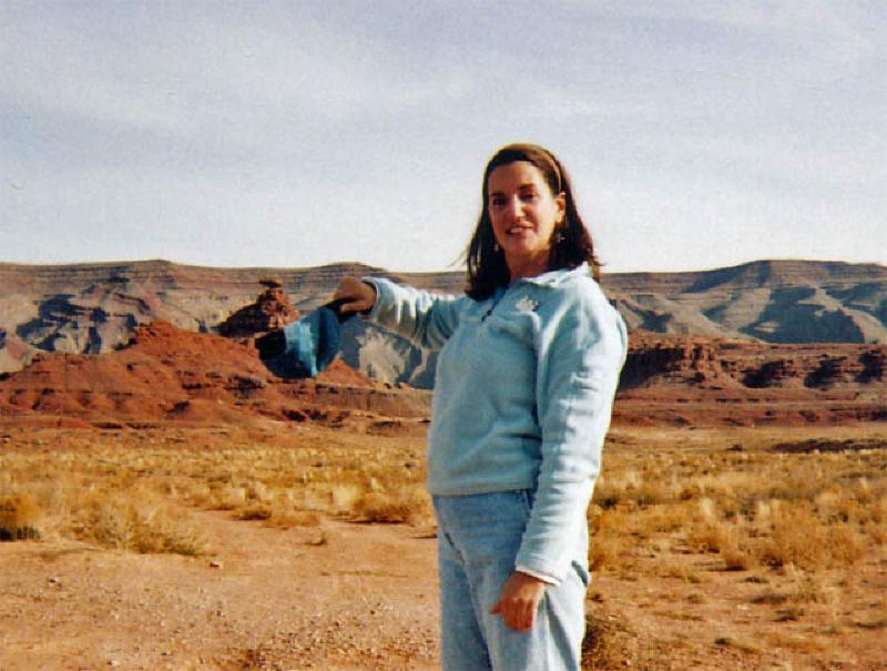 Marla holds her cap beneath the Mexican Hat rock that gives the southeastern Utah town its name.