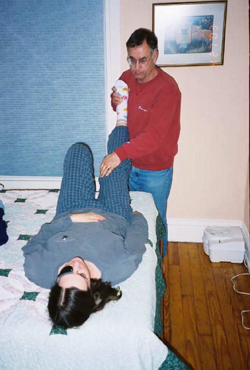 Leo gently stretches Marla's legs before bedtime.