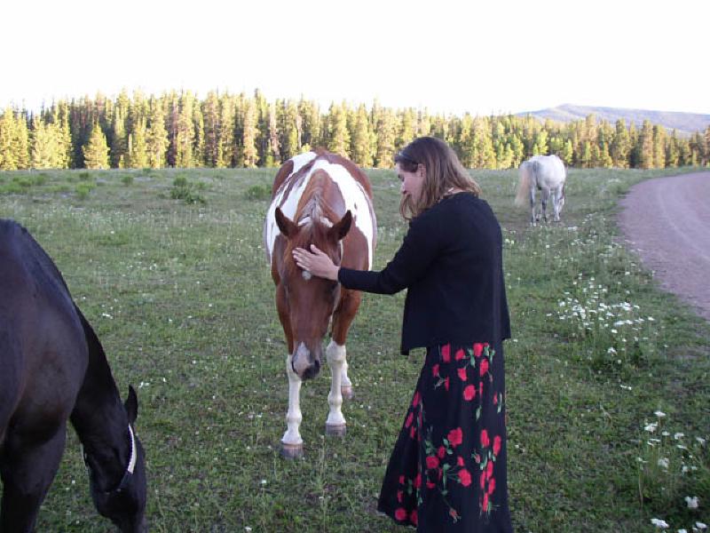 Marla gives a friendly pat to one of the horses at the High Mountain Ranch.
