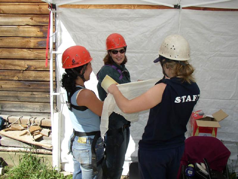 Vikki helps Sally, a BIAC volunteer from Australia, apply a sling and protective paddingto Marla's right arm, which received a new artificial elbow in April. The padding will offerprotection while Marla ascends the climbing wall!