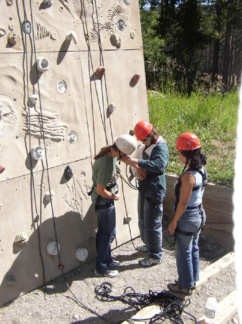 Emily, one of the BOEC staff members in Marla's group, helps her tie in to thetop rope.