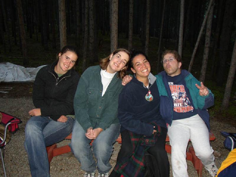 Emily, Marla, Vikki and Harl smile for the camera as they huddle together and enjoythe campfire.