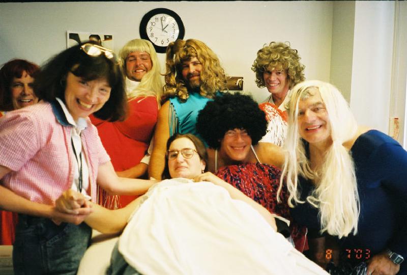 Marla, while working on the physical therapy table with PT Celeste, gets a visit from the crazy Craig staff dressed as "Bosom Buddies".