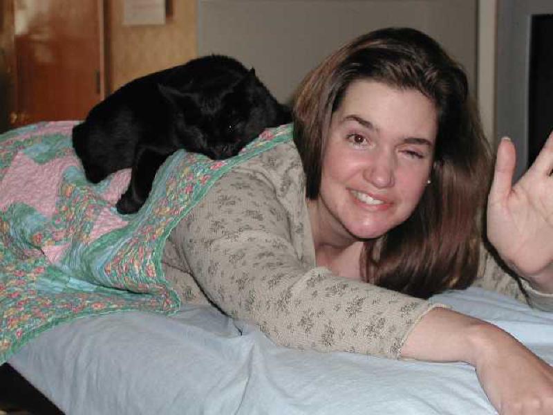 Puck gives Marla some extra warmth and therapy while she's getting ready for stretches on the massage table.